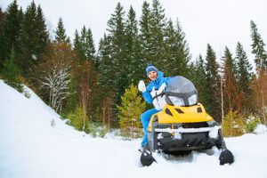 a-woman-is-sitting-on-a-yellow-snowmobile-Muskoka