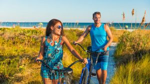 Couple cycling on vacation at the beach