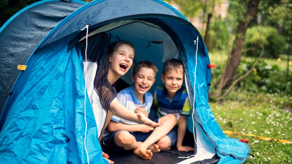 Tent covering with rain on it, children camping
