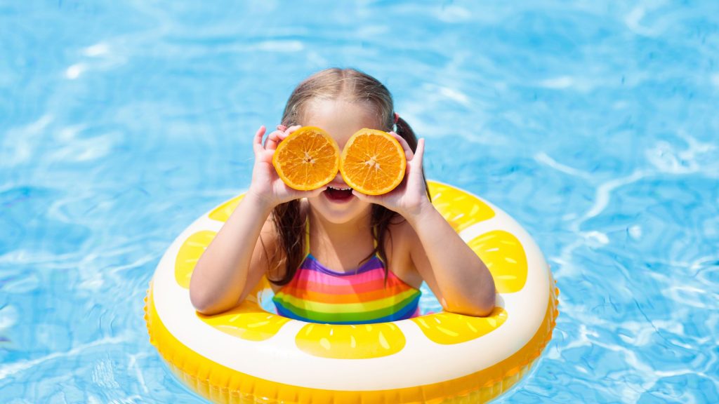 Child with orange and a floatie