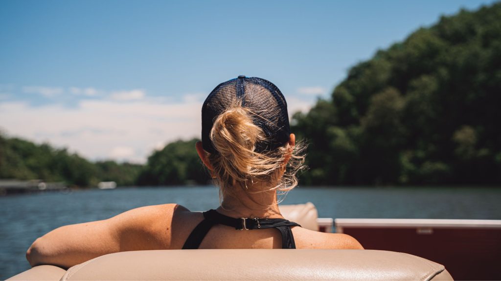 Woman sitting on pontoon boat looking at lake